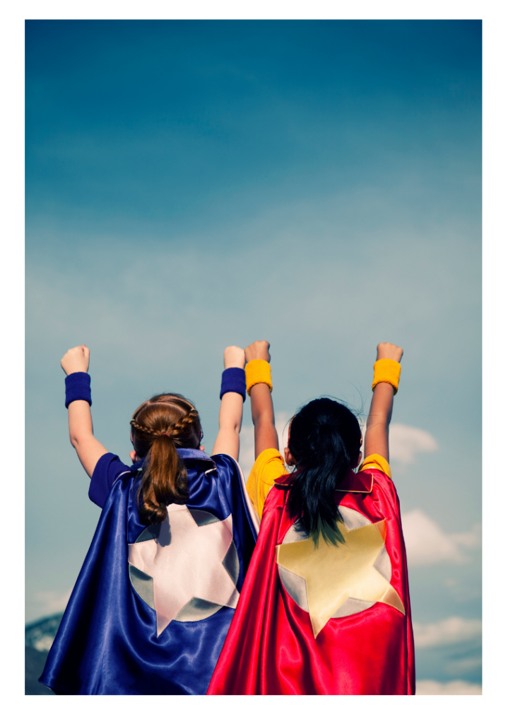 Two girls in capes, back view